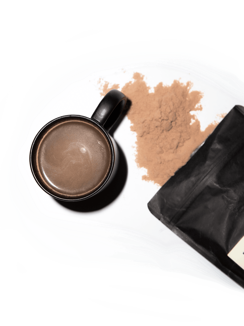 black mug filled with coffee alternative drink and pouch with brown powder